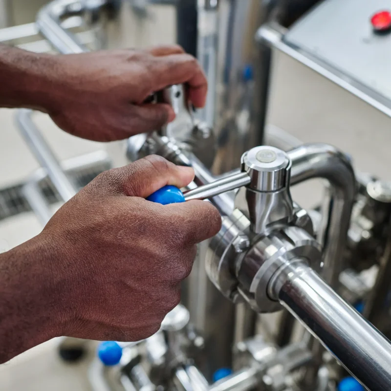 plant-worker-turning-levers-on-pipe-2025-02-11-15-35-16-utc